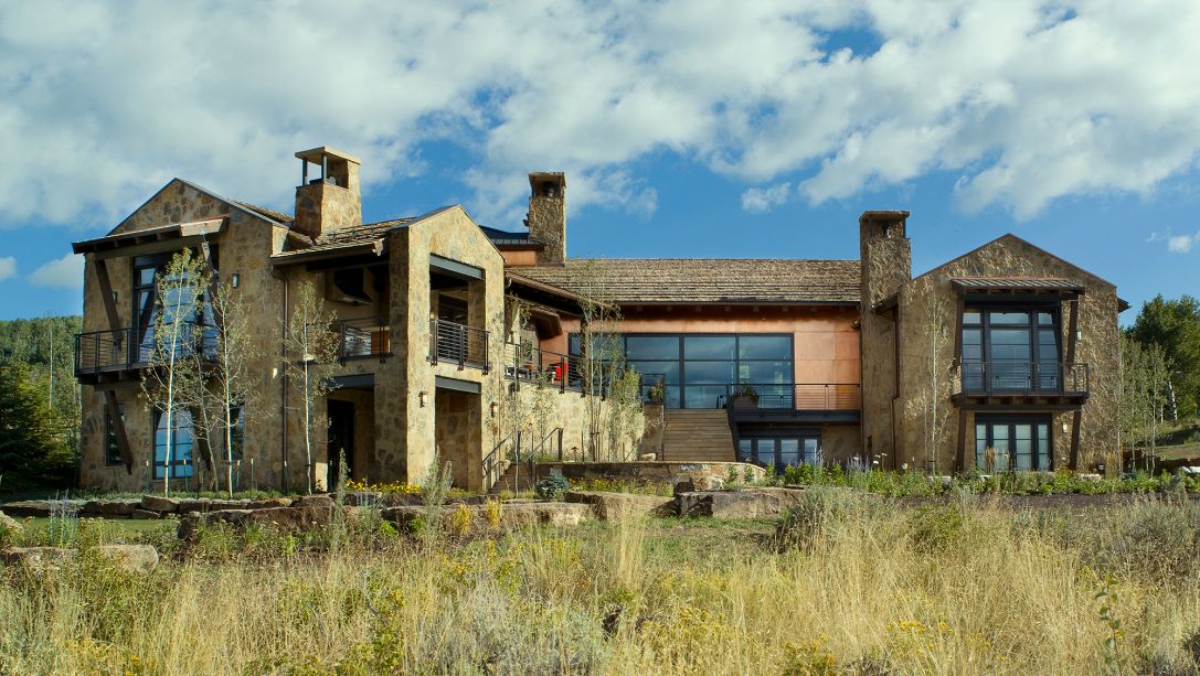 A large house is sitting in the middle of a field.