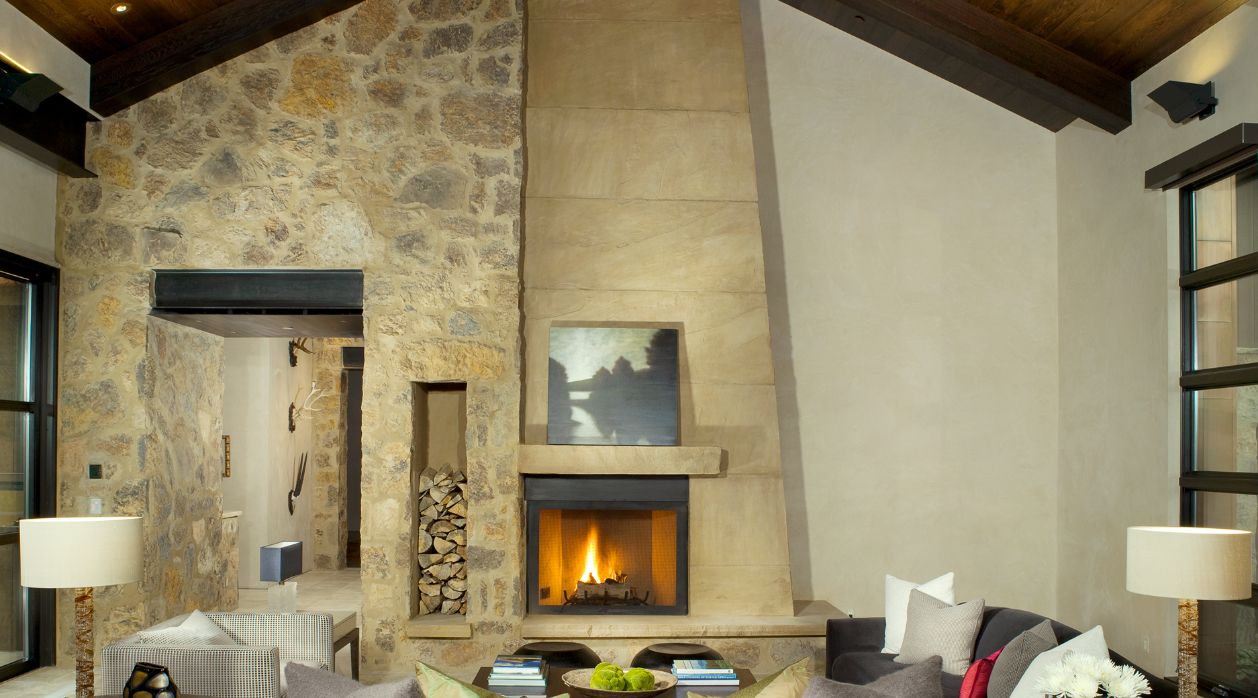 A living room with a fireplace and a stone wall