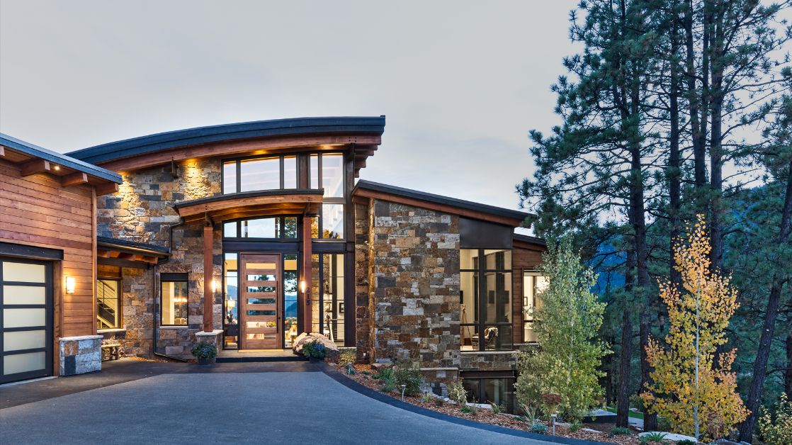 A large house with a lot of windows is surrounded by trees.