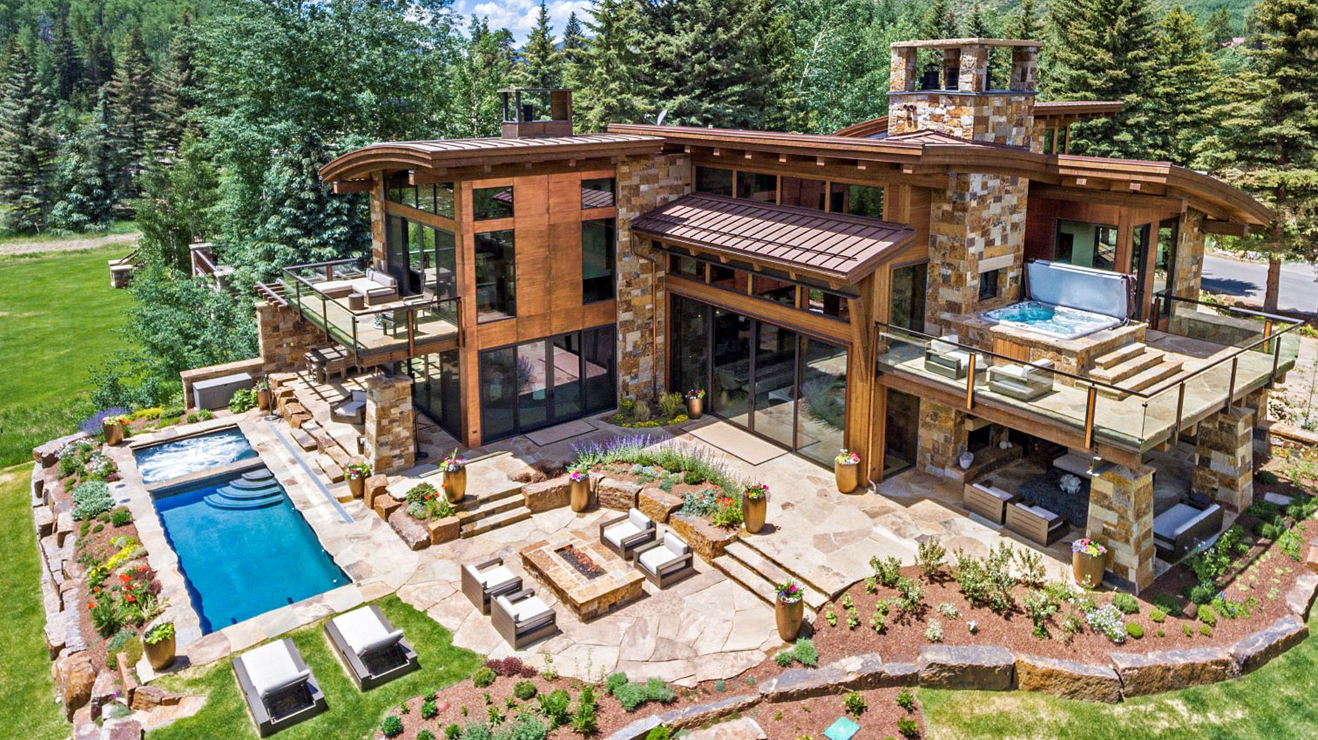 An aerial view of a large house with a swimming pool in the backyard.
