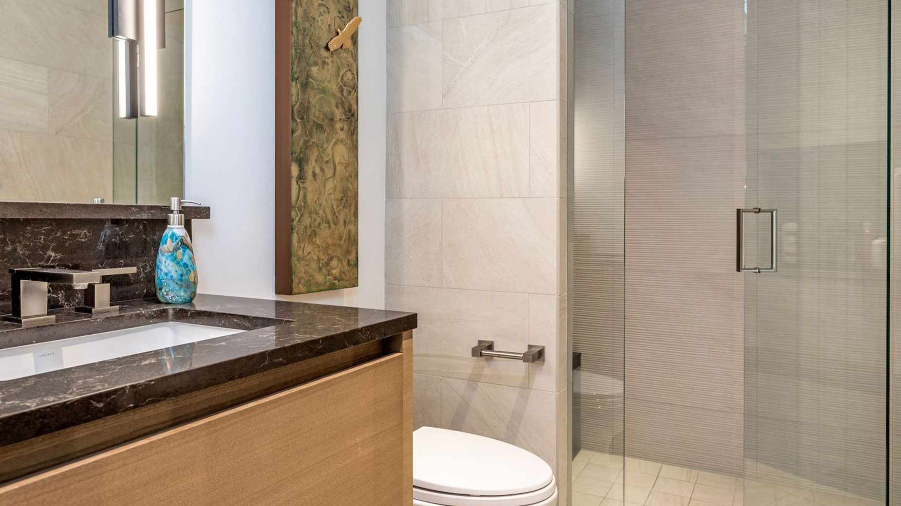 A bathroom with a sink , toilet and walk in shower.