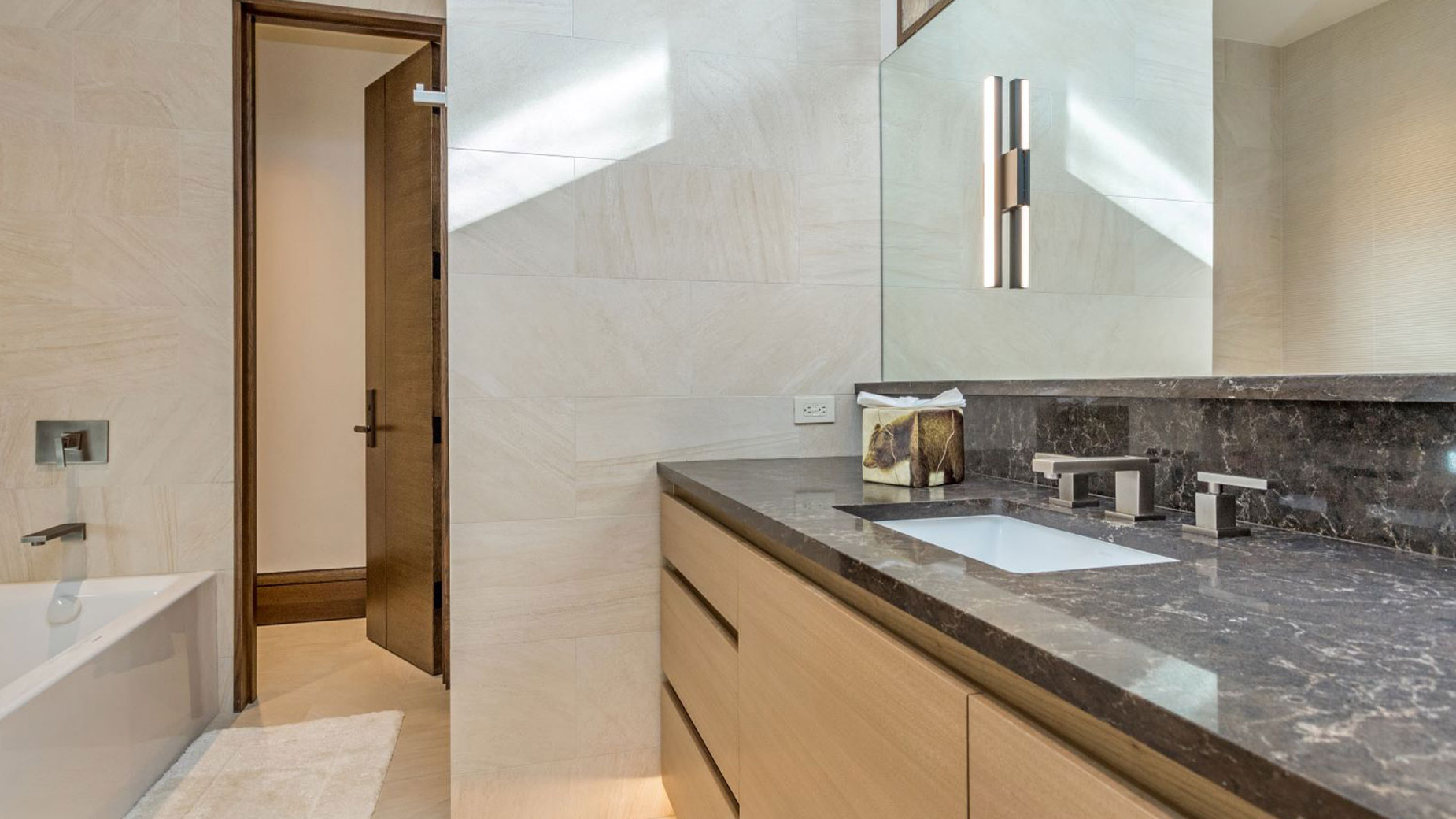 A bathroom with a tub , sink and mirror