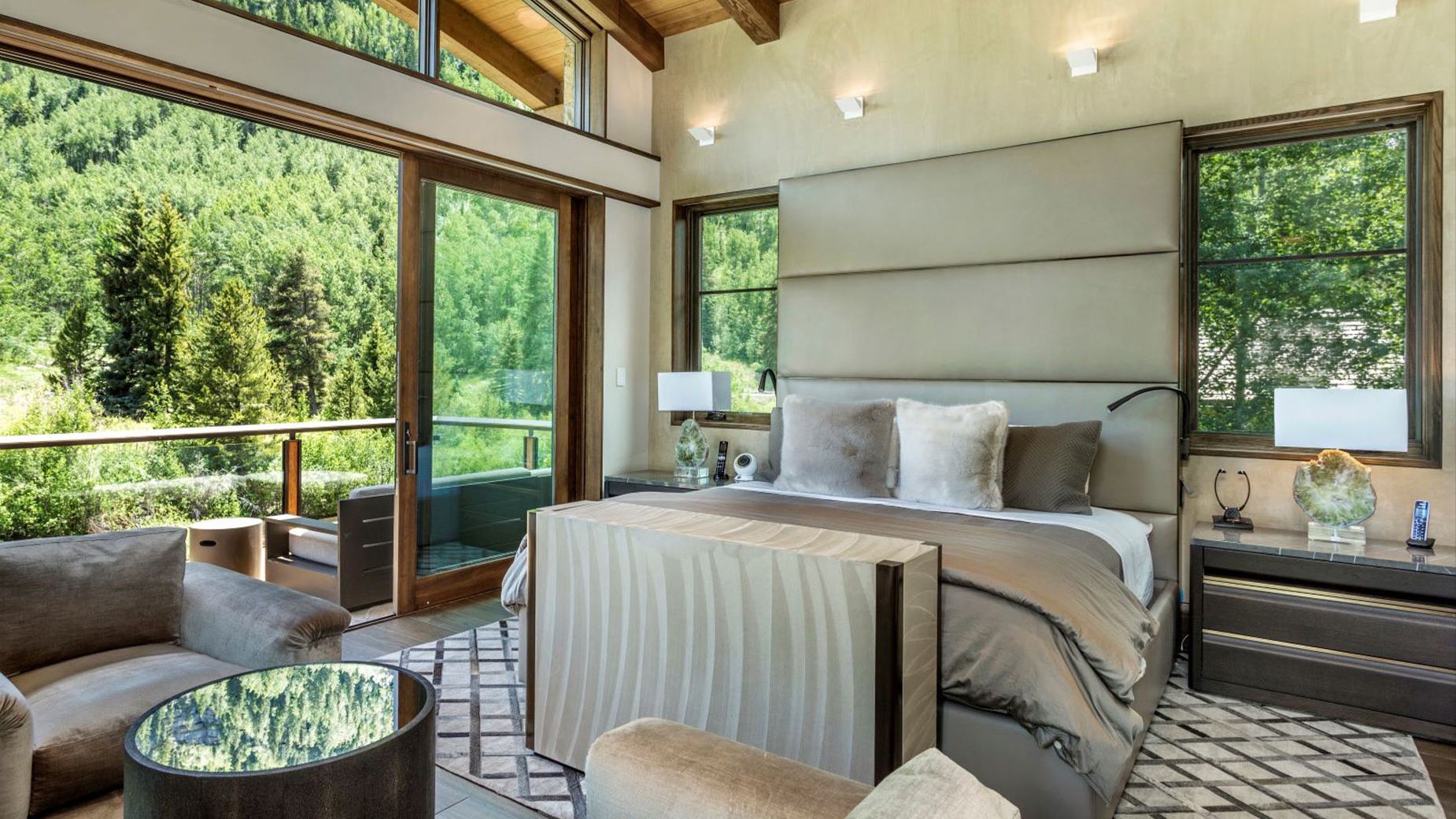 There is a large bed in the middle of the room with a lot of windows.