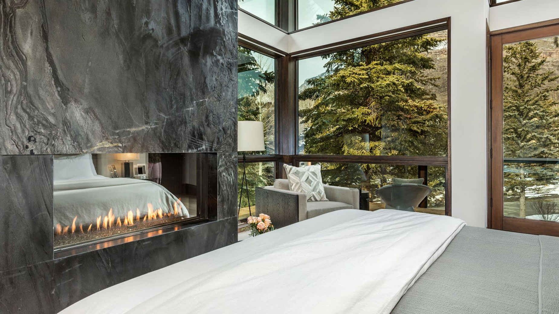 A bedroom with a fireplace and a large bed.