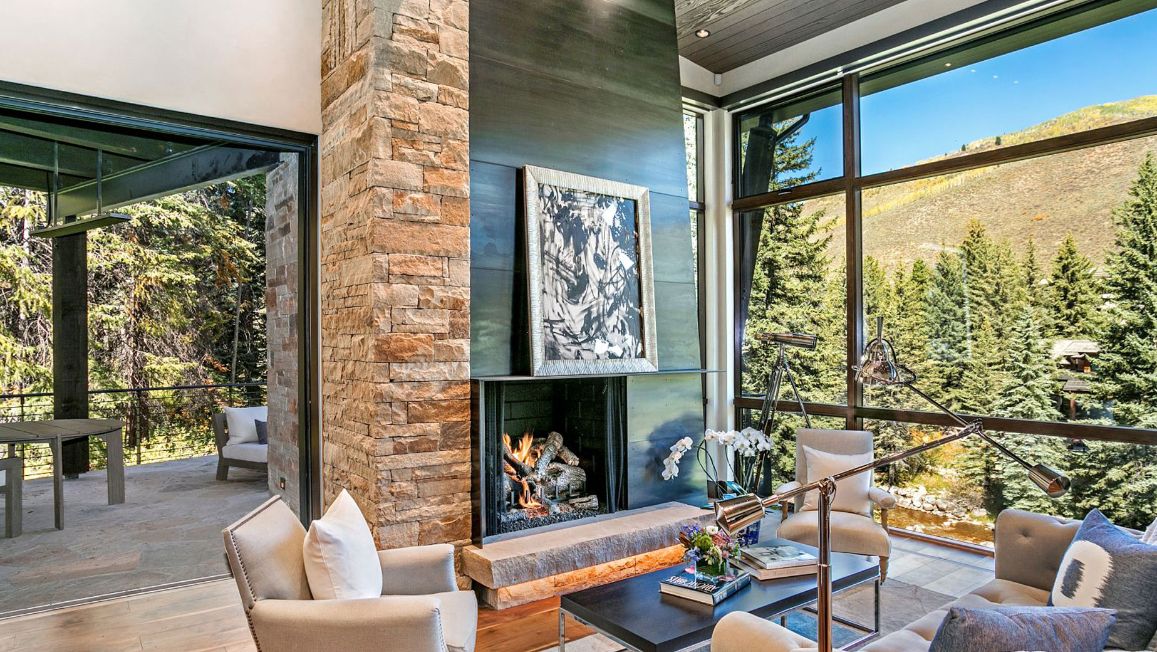 A living room with a fireplace and a view of the mountains.