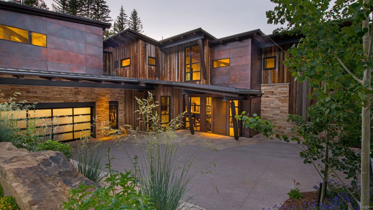 A large house with a lot of windows is surrounded by trees.