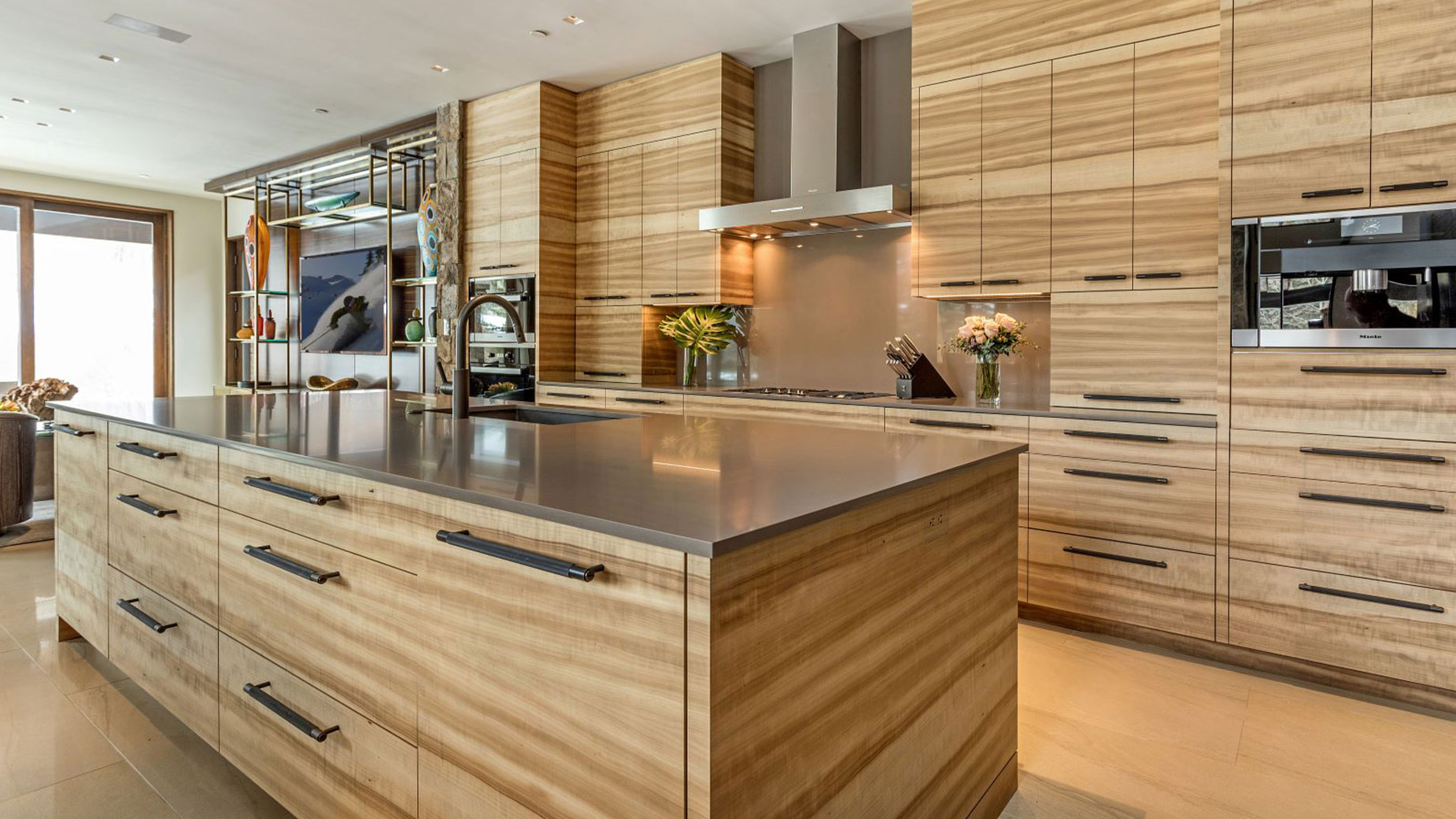 A kitchen with wooden cabinets and a large island in the middle.