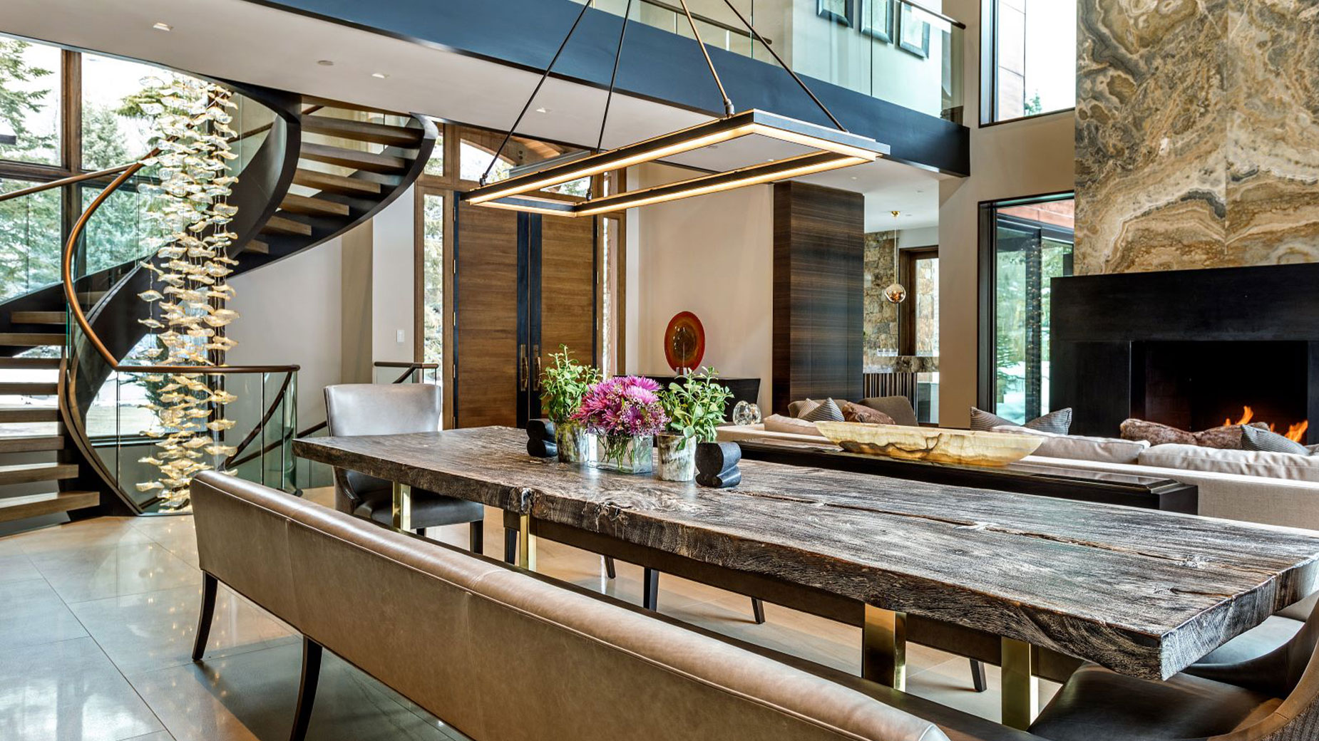 A large dining room with a long table and a fireplace.