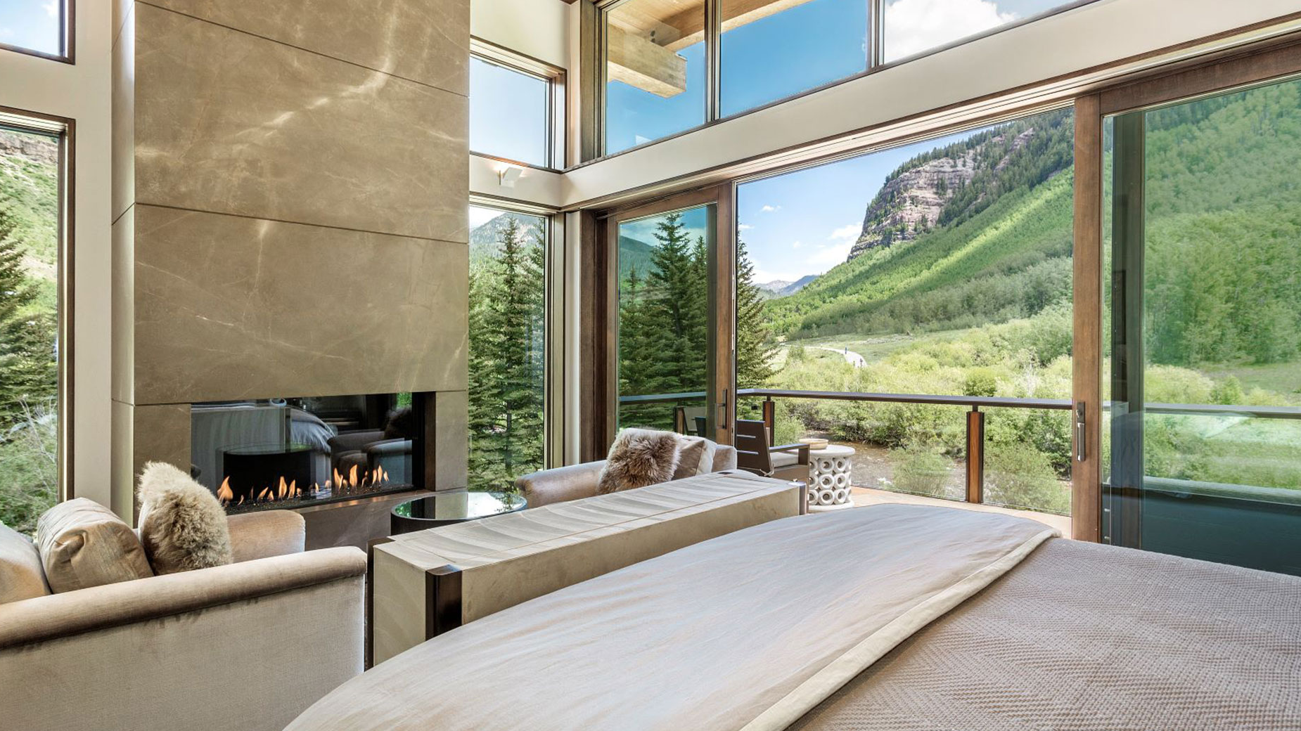 A bedroom with a fireplace and a view of a mountain.