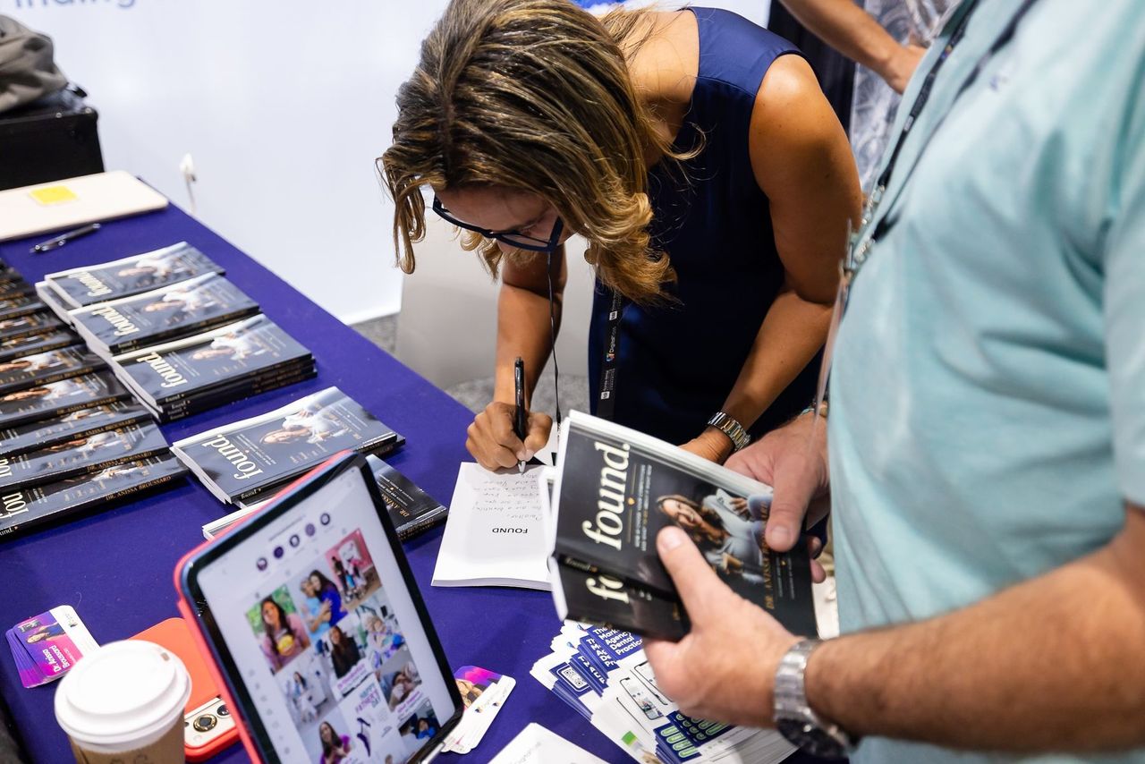 Dr. Anissa Broussard signing copies of FOUND at the Florida Dental Convention