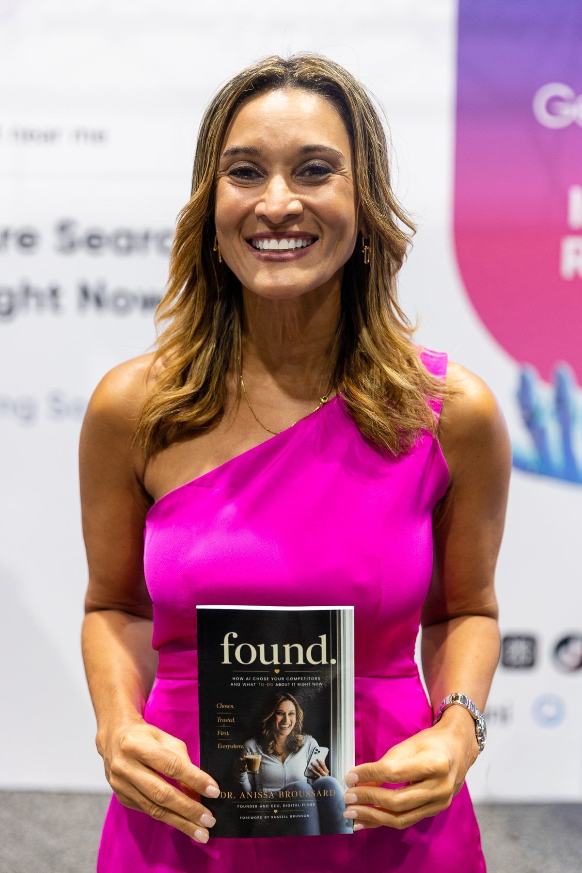 Dr. Anissa Broussard in a pink dress holding FOUND at the Florida Dental Convention 2026