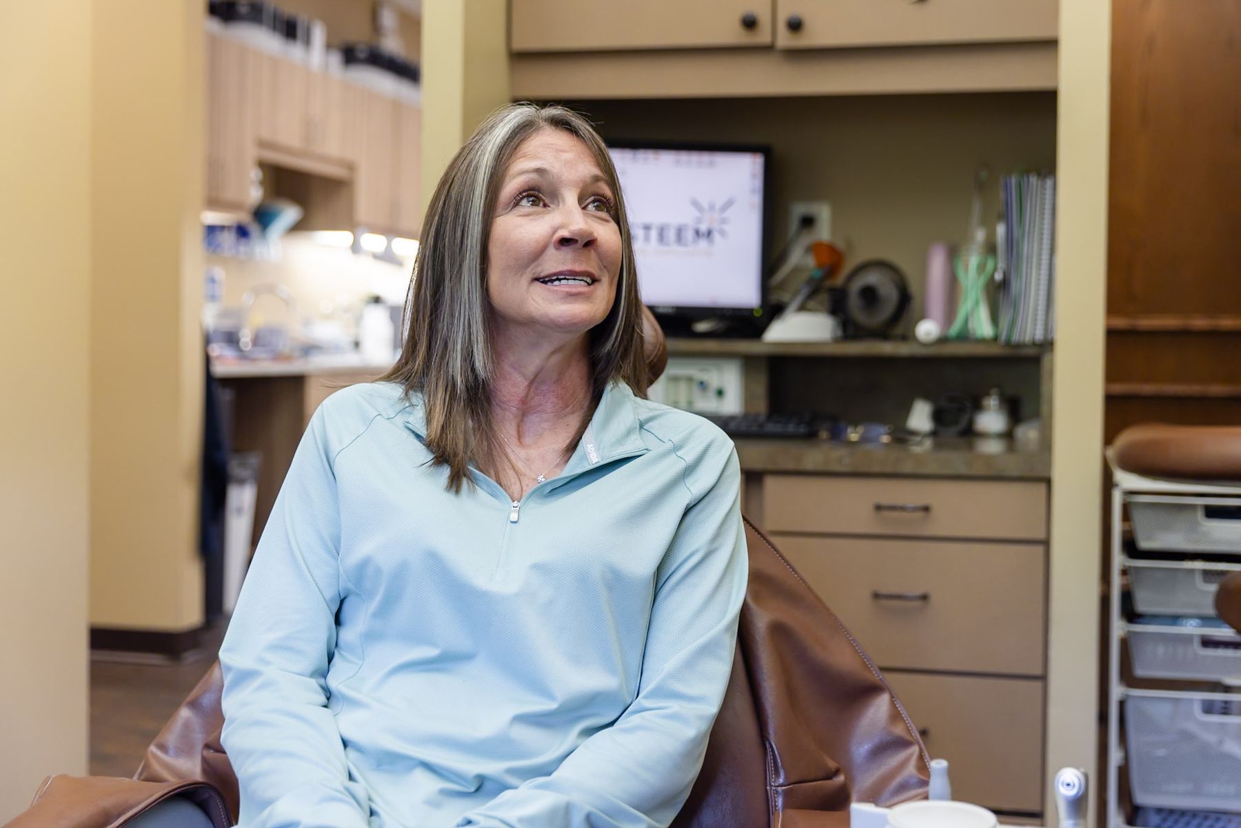 A patient talking with her care team in a treatment room at Granbury Dental Center