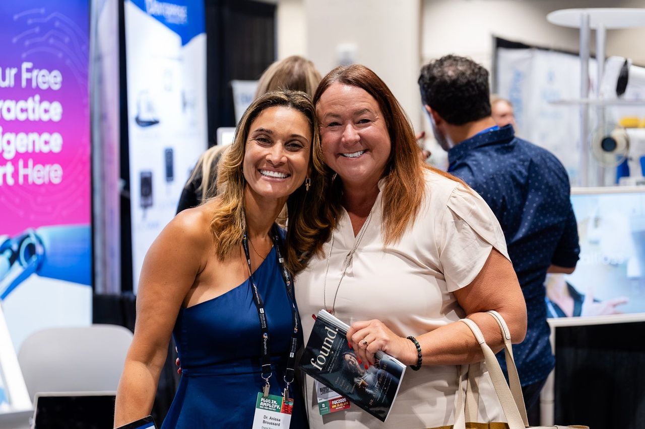 Dr. Anissa Broussard with a smiling attendee who is holding a copy of FOUND at the Florida Dental Convention 2026