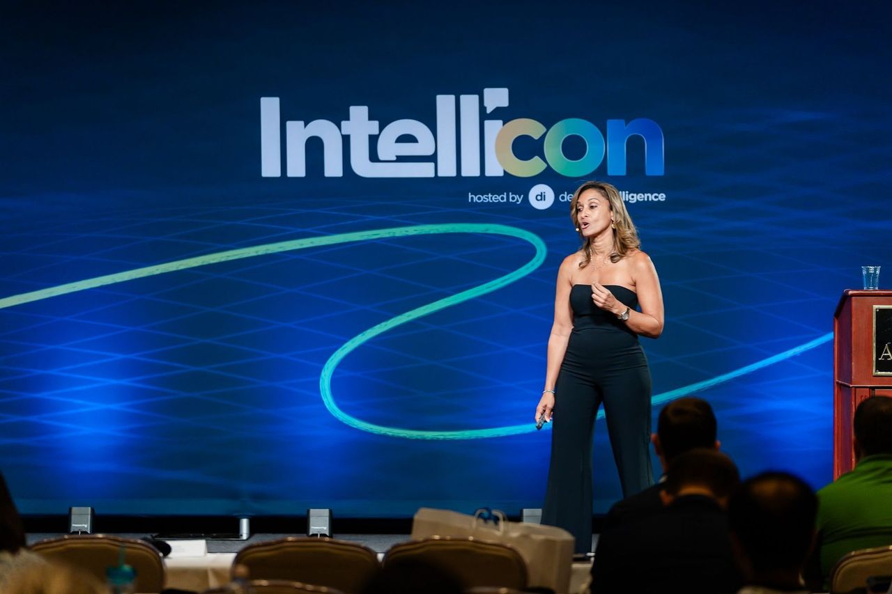 Dr. Anissa Broussard speaking on the Intellicon main stage in front of the Intellicon backdrop
