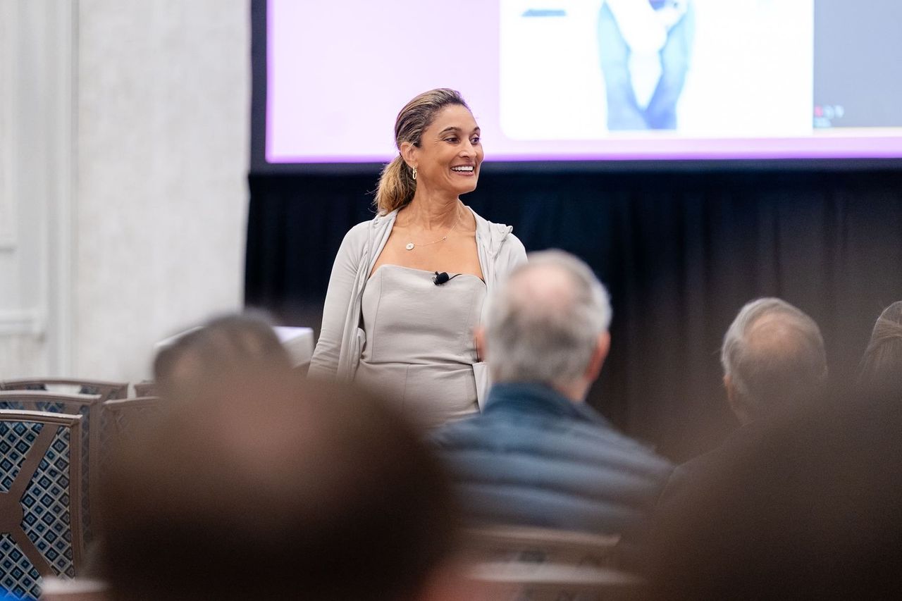Dr. Anissa Broussard smiling as she teaches a full room at the Mid-Continent Dental Congress