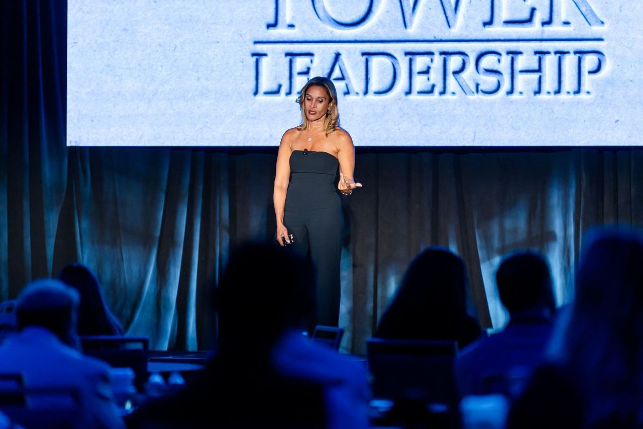 Dr. Anissa Broussard speaking under the Tower Leadership screen to a full room