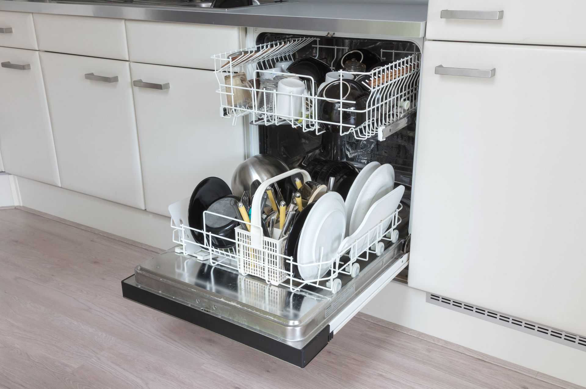 Open dishwasher with dishes loaded in a modern kitchen