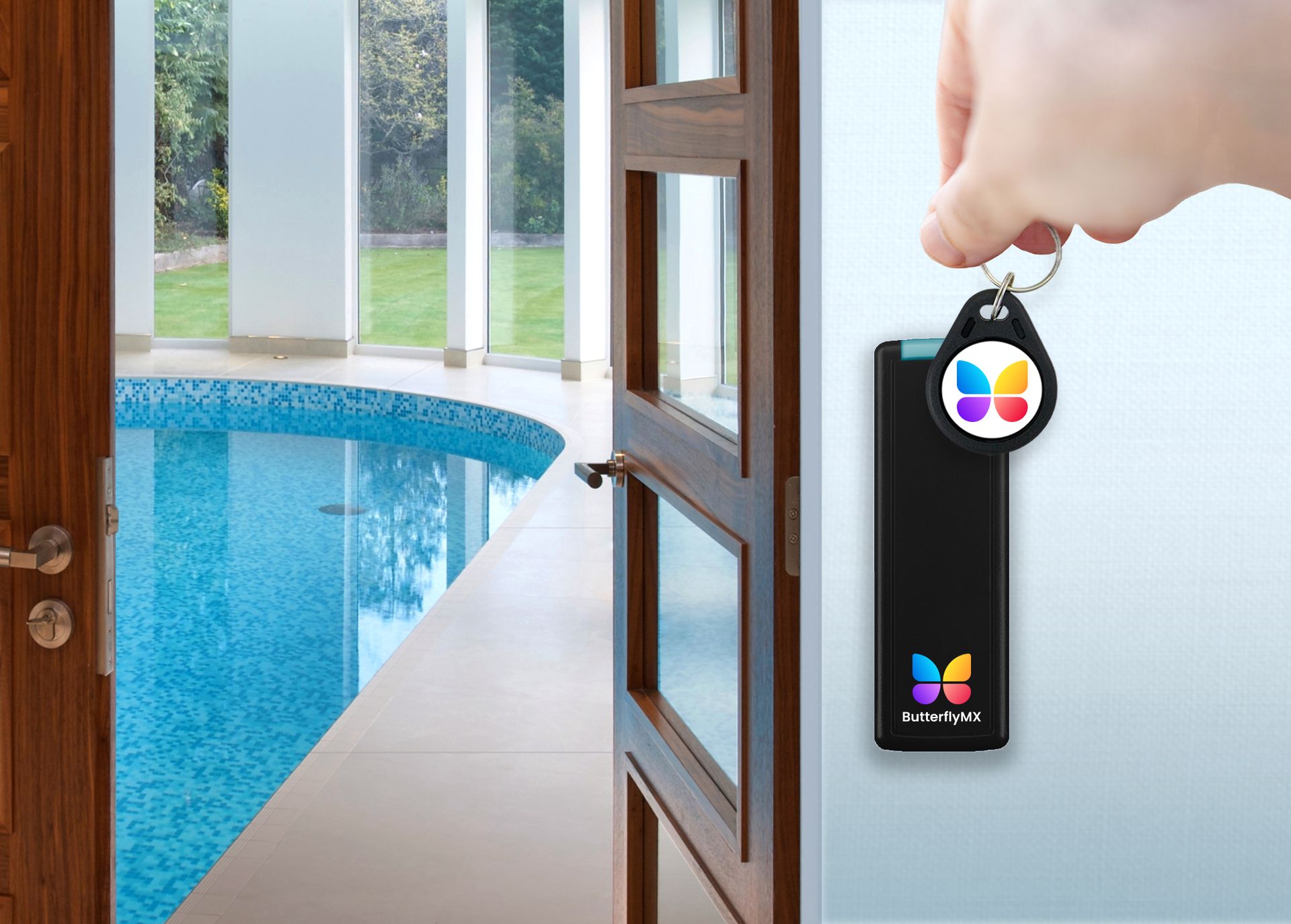 A hand holds a butterfly-branded electronic key fob next to a door opening into an indoor swimming pool room.
