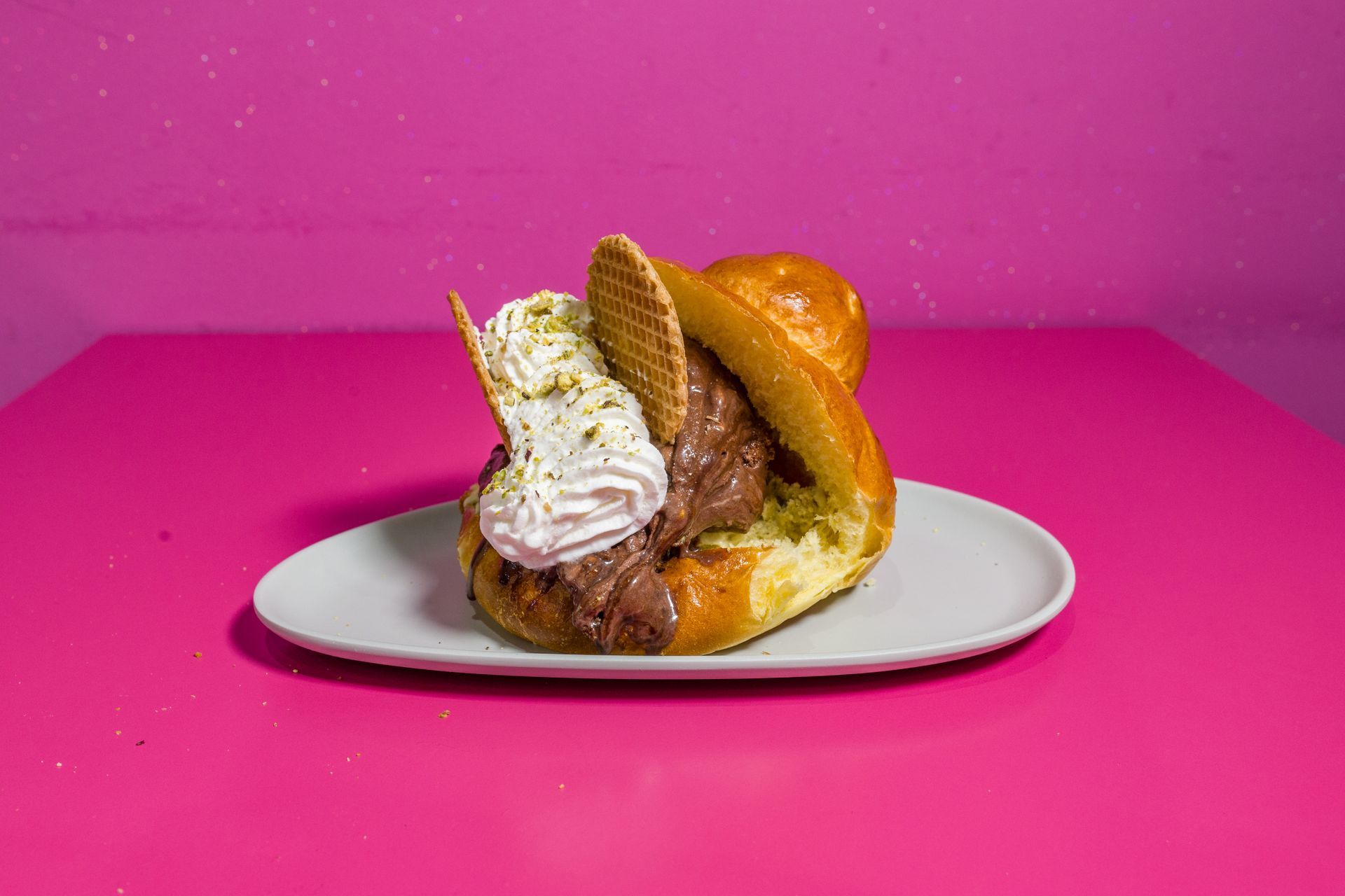 Dessert su un piatto bianco su uno sfondo rosa acceso