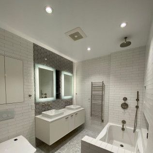 Modern white bathroom with double vanity, mirrors, towel radiator, and bathtub shower combo