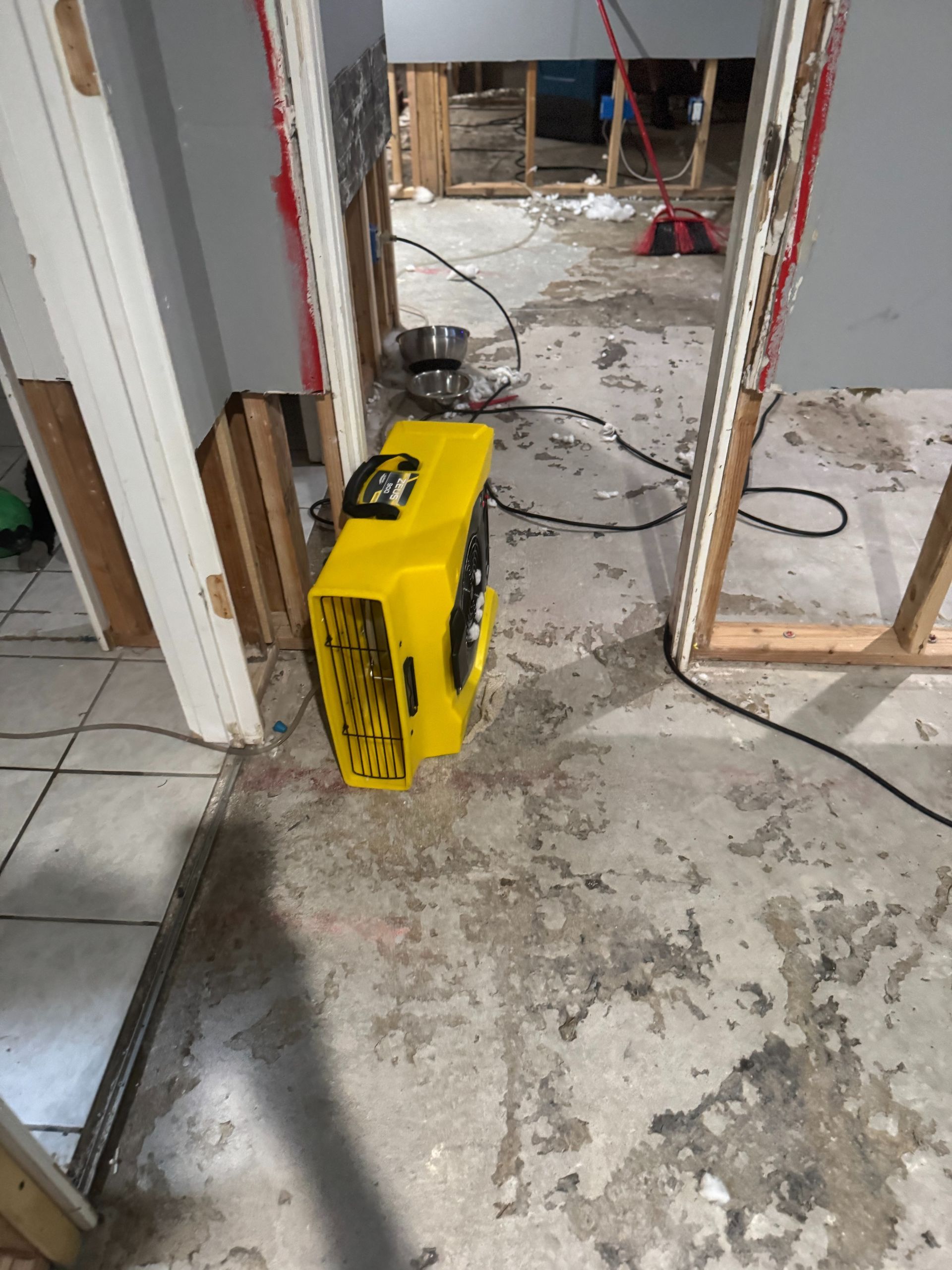 Yellow heater on a dusty floor in a doorway during home renovation