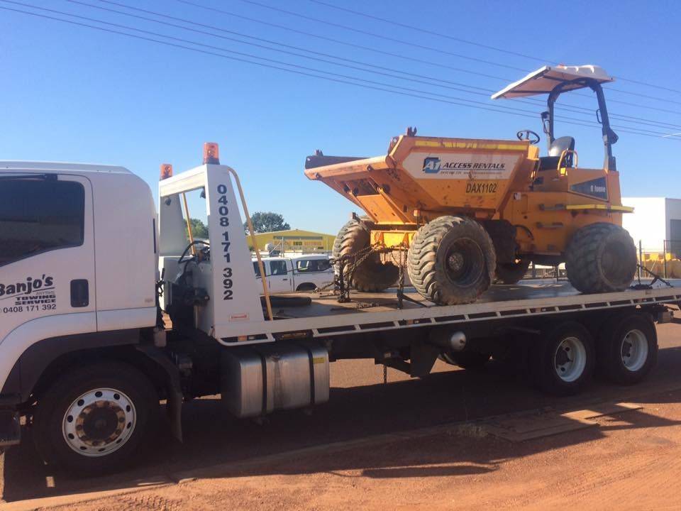 Yellow Dump Truck on a Flatbed Tow Truck, Outdoors — Banjo's Anytime Towing in Humpty Doo, NT