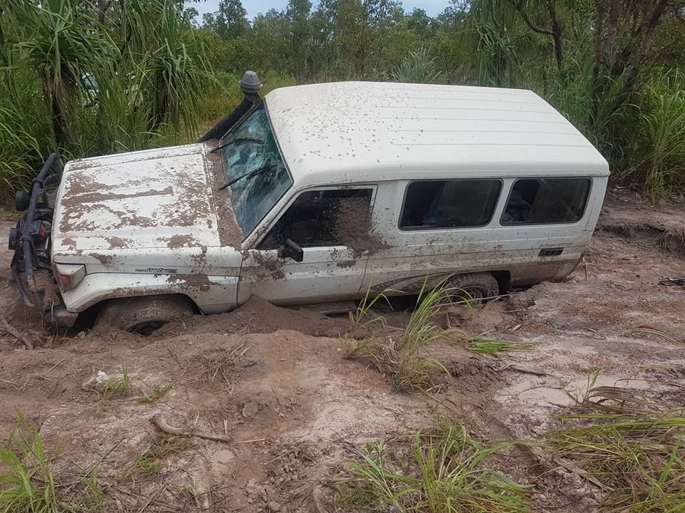 White SUV stuck in deep mud with surrounding greenery — Banjo's Anytime Towing in Humpty Doo, NT