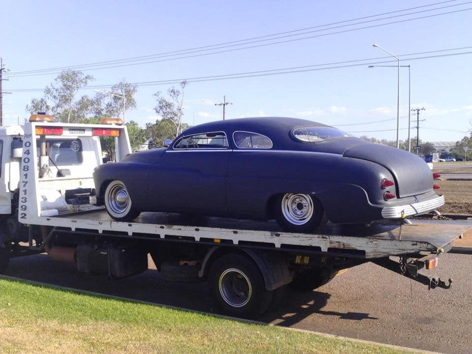 Black custom car on a flatbed tow truck on a sunny day — Banjo's Anytime Towing in Humpty Doo, NT