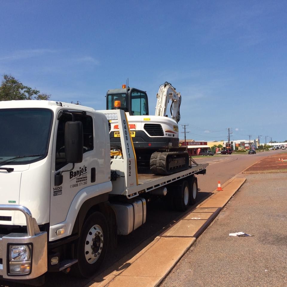 White Tow Truck Carrying an Excavator on a Sunny Day — Banjo's Anytime Towing in Humpty Doo, NT