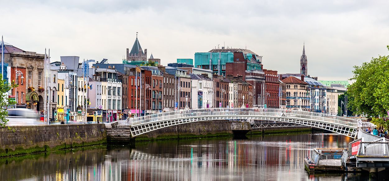 A bridge over a river in a city with buildings in the background.