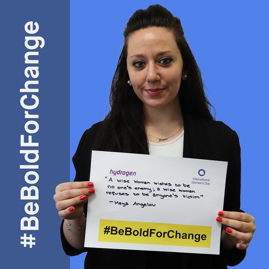 A woman is holding a sign that says be bold for change