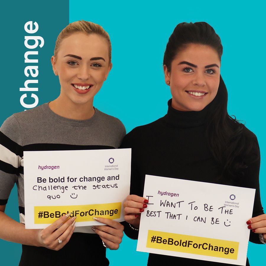 Two women are holding signs that say be bold for change