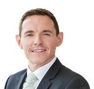 A man in a suit and tie is smiling for the camera.