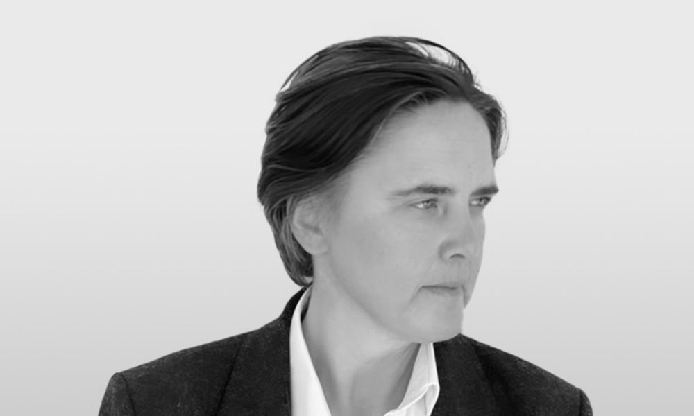 A black and white photo of a woman in a suit and white shirt.