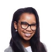 A young woman wearing glasses and earrings is smiling for the camera.