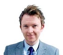 A man in a suit and tie is smiling for the camera.