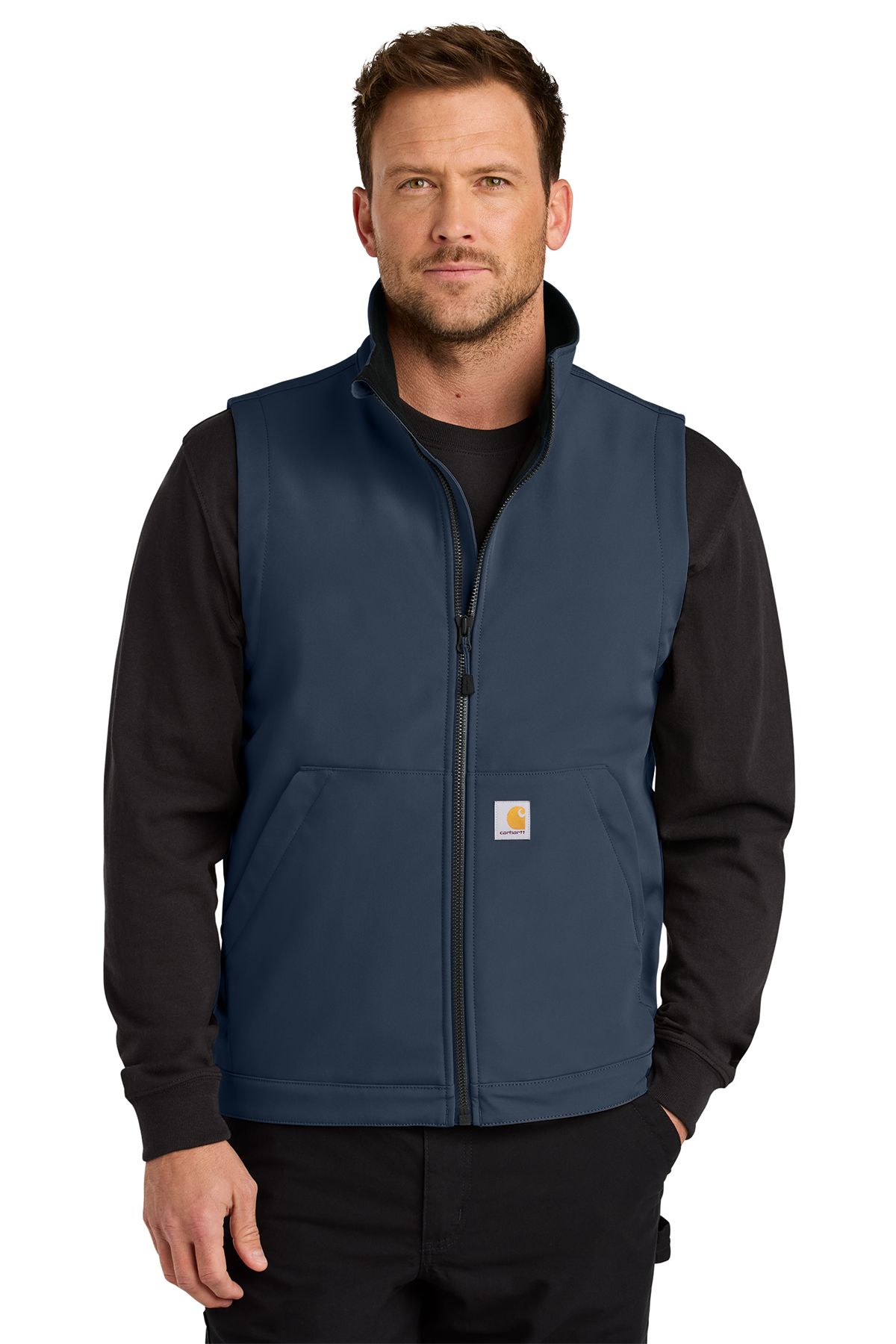 Man wearing a black Carhartt vest over a black long-sleeved shirt; a neutral expression.