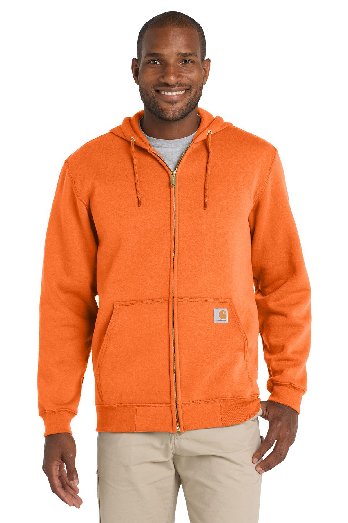 Man in neon yellow zip-up hoodie and khaki pants smiles.