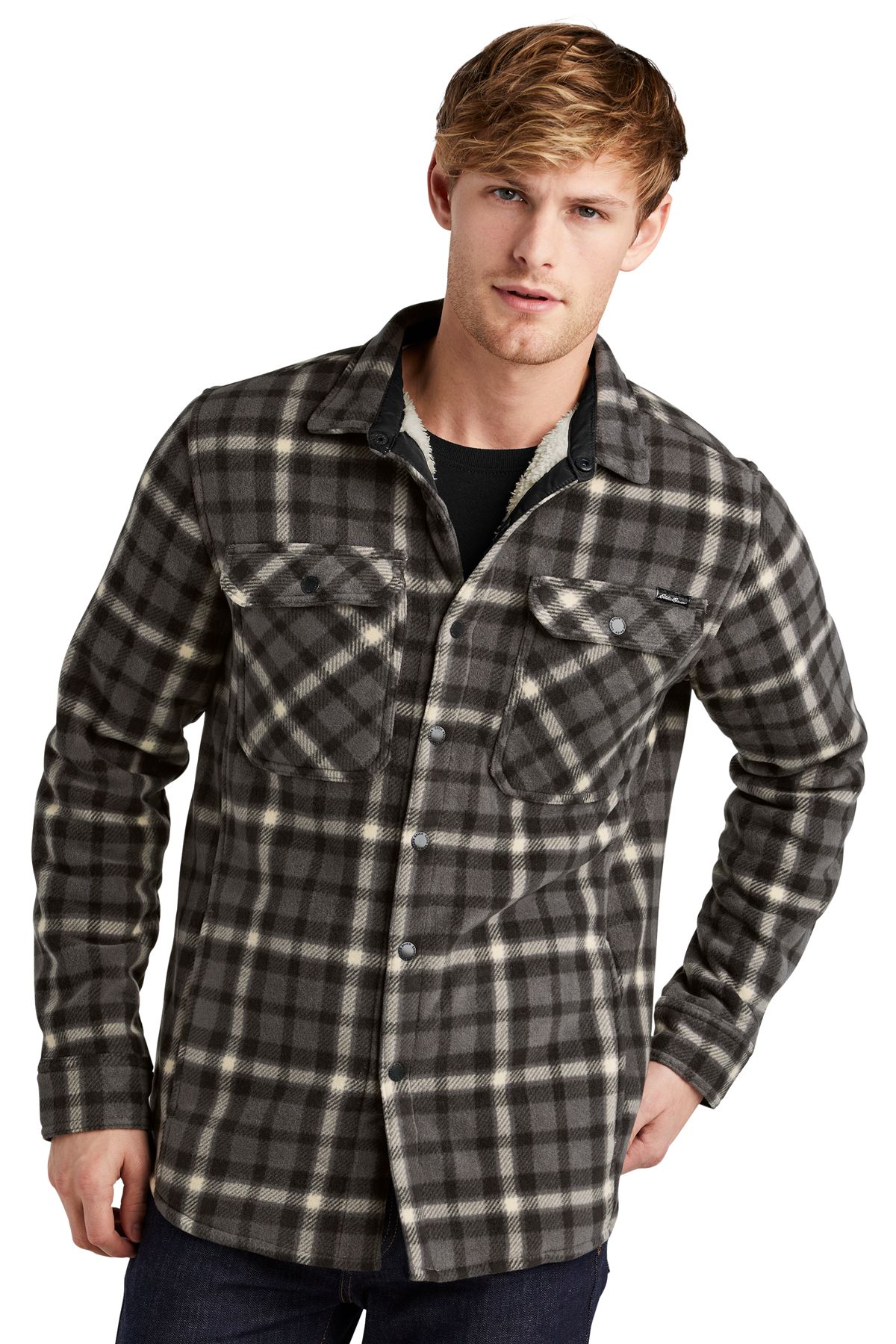 Man wearing a red and black plaid fleece shirt over dark jeans.