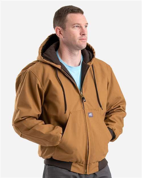 Man in a brown hooded work jacket with hands in pockets.