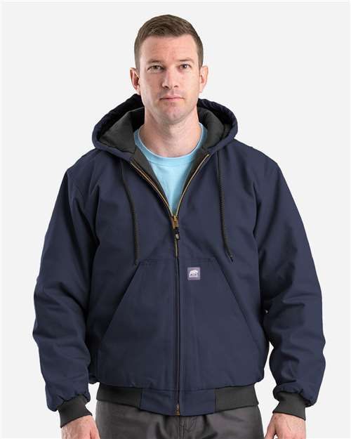 Man in camo jacket with hood smiles.