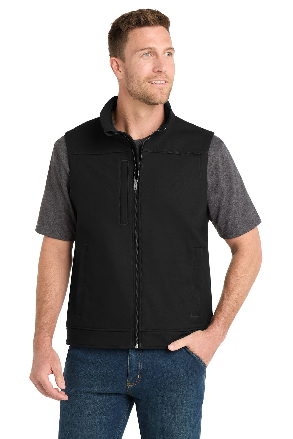 Man wearing a black vest and gray shirt, standing, smiling.
