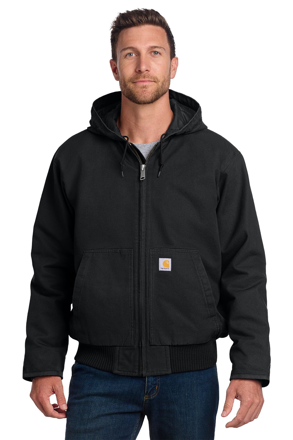 Man in brown hooded Carhartt jacket, dark blue jeans; neutral expression.