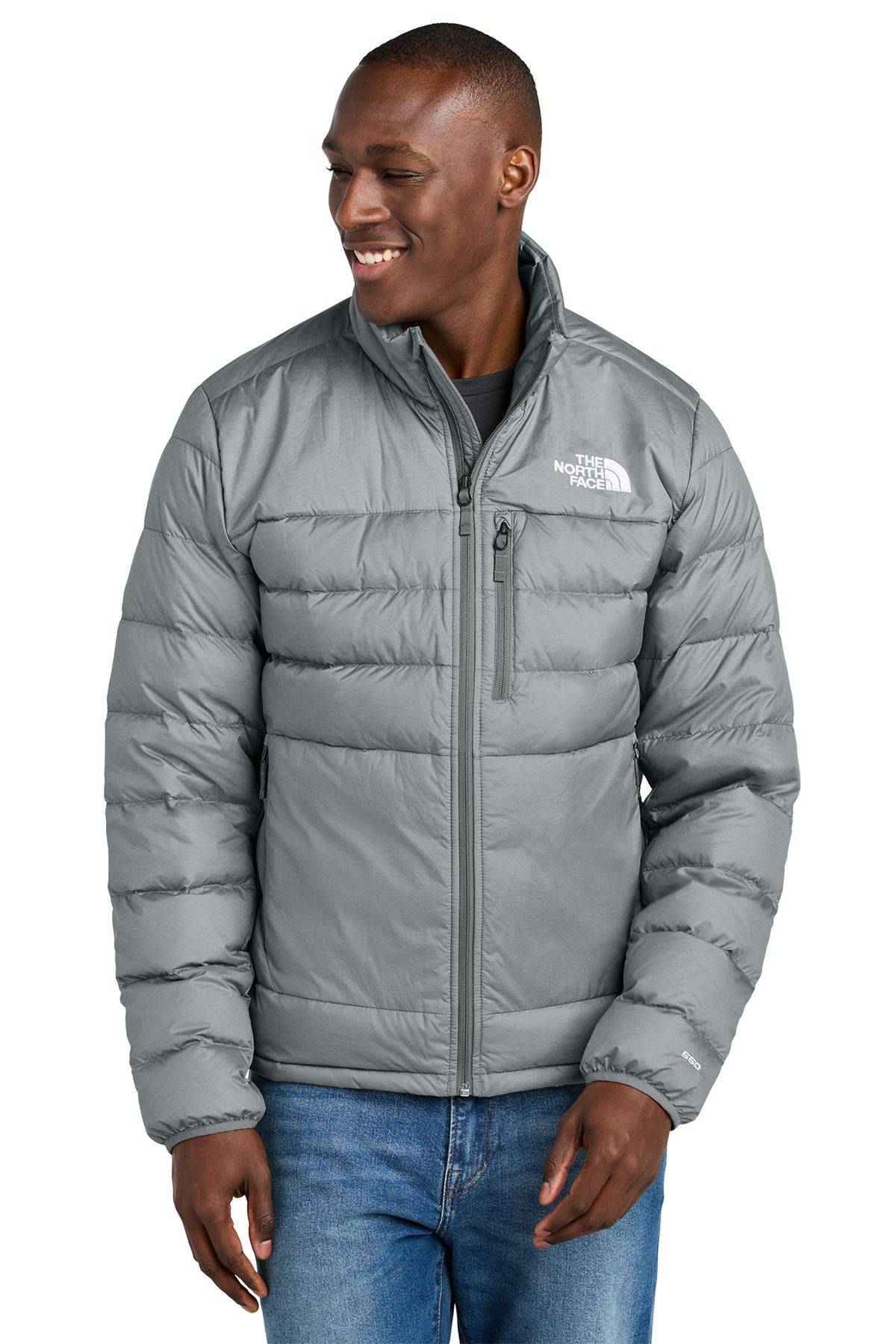 Man wearing a green puffer jacket, standing in front of a white background.