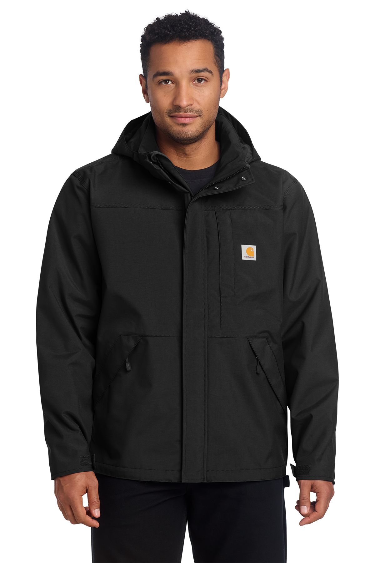 Man wearing black Carhartt jacket with hood, standing in front of white background.