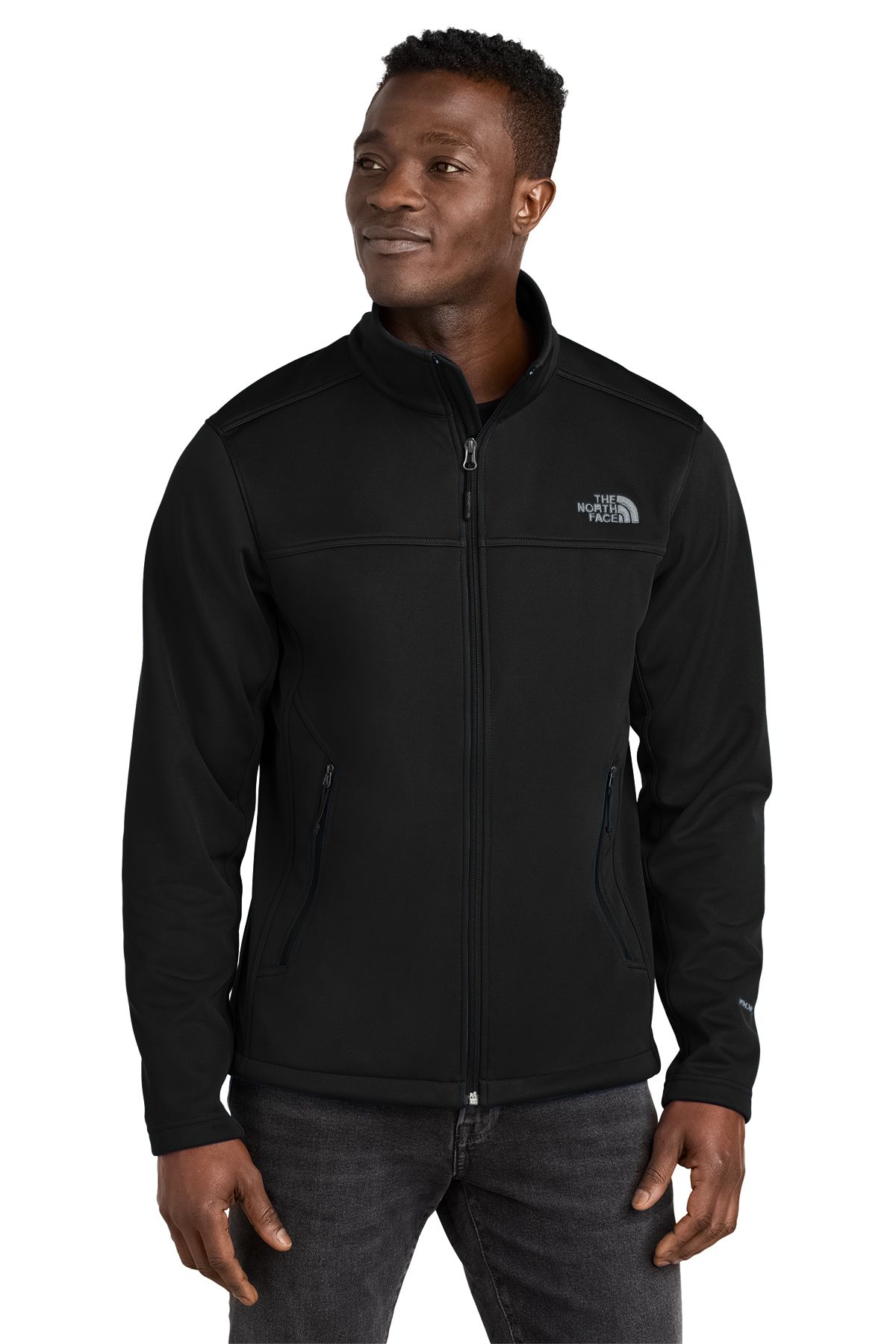 Man in a black North Face jacket, zipped up. He is smiling and standing in front of a white background.