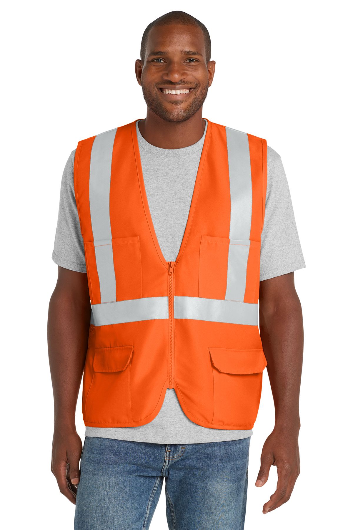 Man wearing a high-visibility lime green vest with reflective stripes over a gray shirt and jeans, smiling.