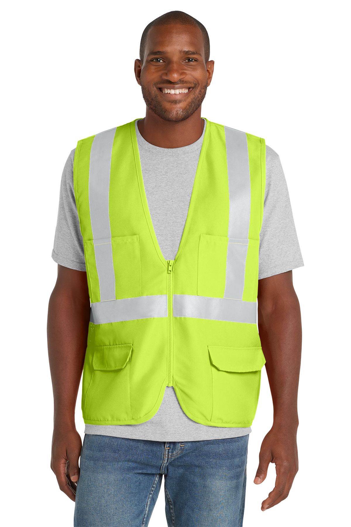 Man wearing a high-visibility lime green vest with reflective stripes over a gray shirt and jeans, smiling.
