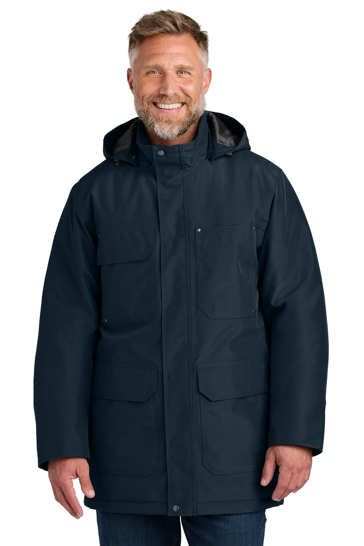 Man in a black winter coat with a hood and multiple pockets, smiling.