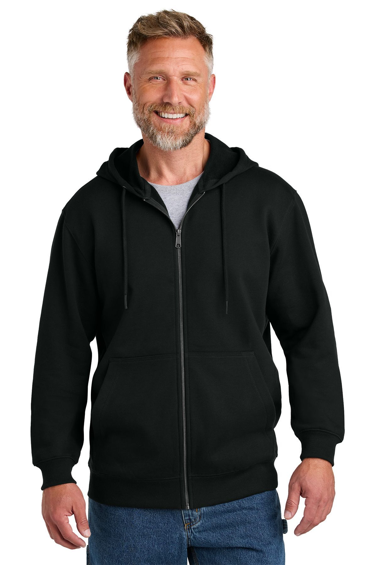 Man in a black zip-up hoodie, gray shirt underneath, smiling, blue jeans.